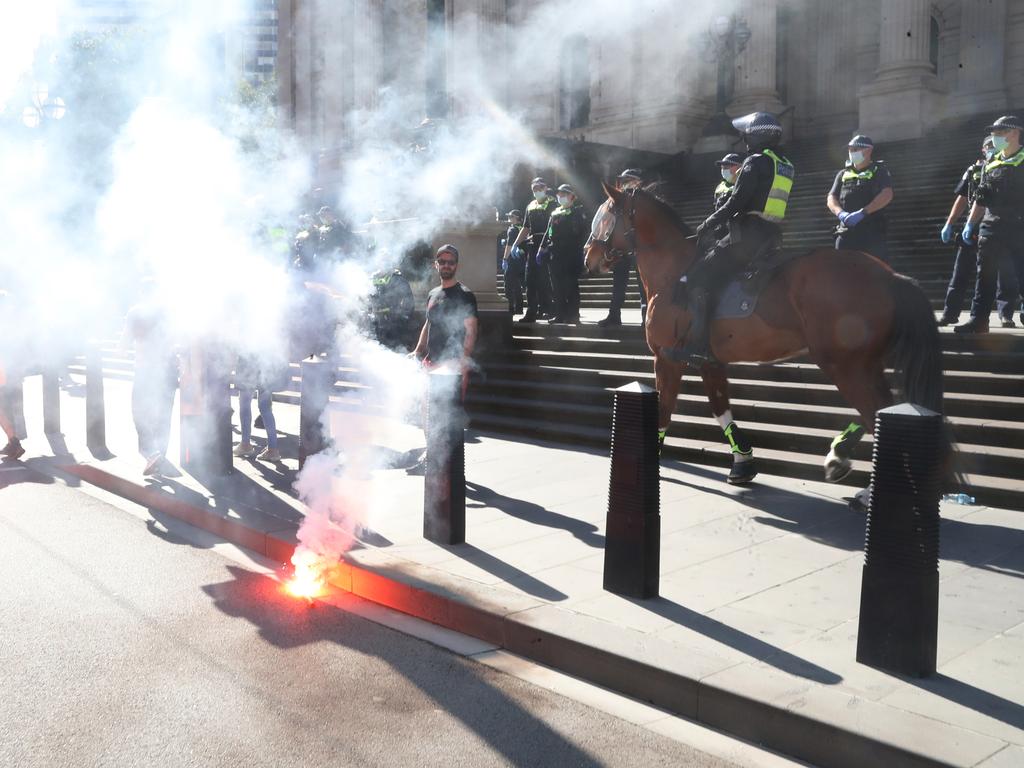 Flares were lit as protesters clash with police in Melbourne. Picture: David Crosling