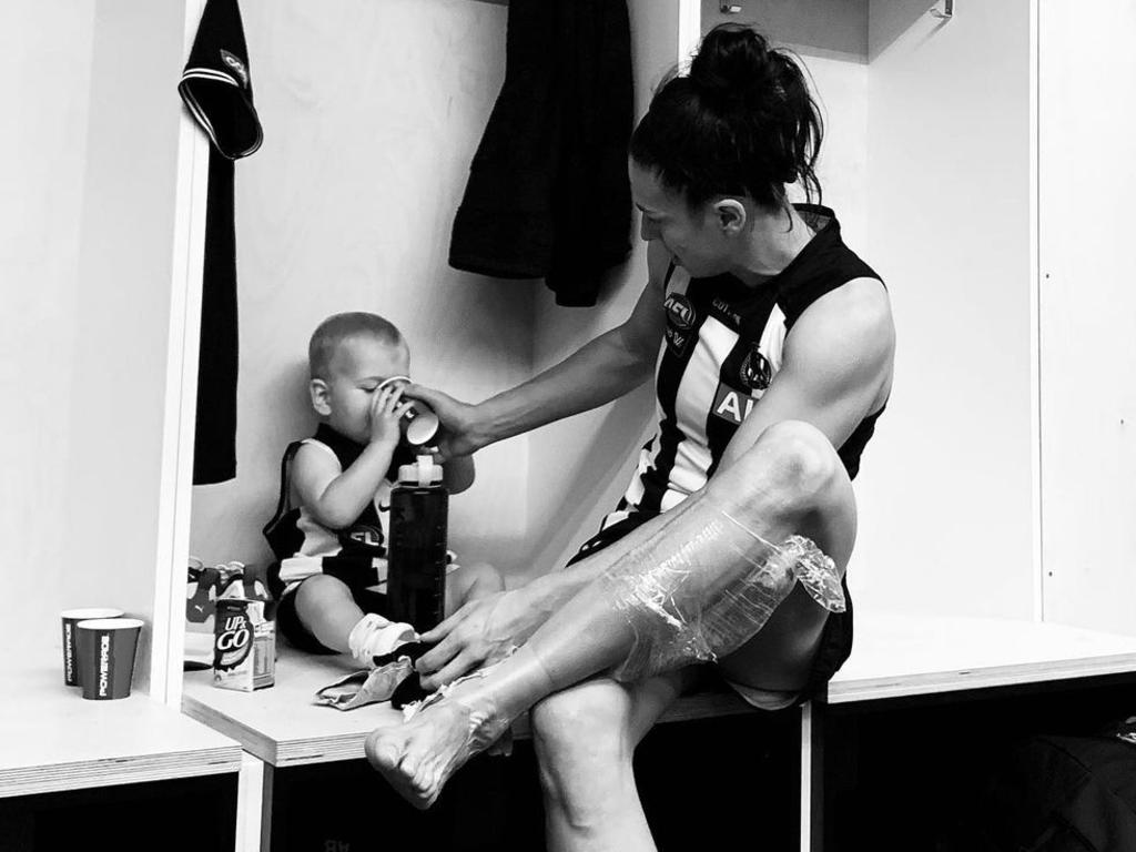 Collingwood's Ash Brazill in the changerooms with her son, Louis, after winning her AFLW comeback game. Picture: Amelia Velardo/Collingwood AFLW player