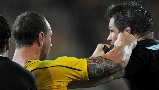 Quade Cooper of Australia clashing with New Zealand captain Richie McCaw in 2011.