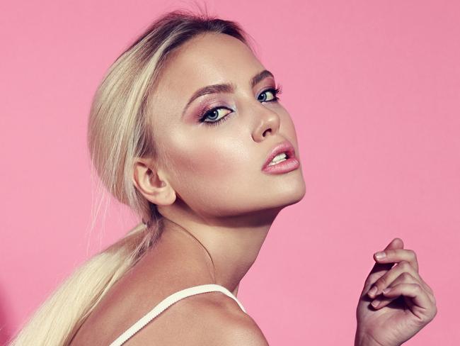 Istock photo for beauty column in Gold Coast Eye Jan 20Sexy bright makeup blond woman posing sitting on the chair in white top on pink background. Toned closeup portrait