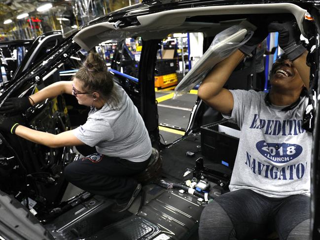 The US Federal Reserve says US exports have weakened as Ford workers Jasmine Powers (R) and Cassie Bell (L), both of Louisville, Kentucky, install visors into the all-new 2018 Ford Expedition SUV. Picture: AFP