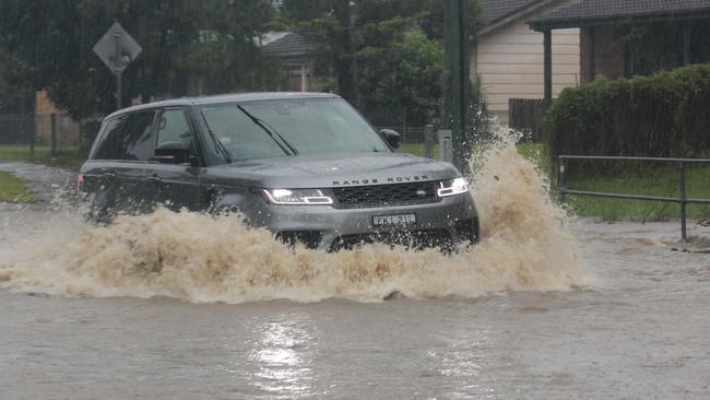 Flooding on Bray St, Coffs Harbour on Wednesday March 18. Cars unwilling to take a 1 minute and 47 second detour drive through floodwaters on Bray St after Council closed the road. Coffs Harbour floods.