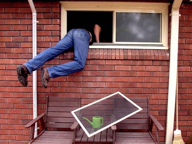 Generic photograph of a burglar thief breaking into a house through an unlocked window. burglary theft larceny. PIRATE: 28/02/2001.