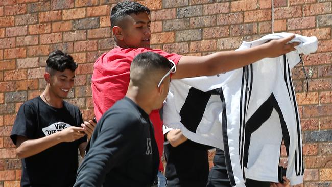 A group of young boys outside Broadmeadows Magistrates’ Court shield Michelle Kaye Mercieca from the waiting media. Picture: Yuri Kouzmin