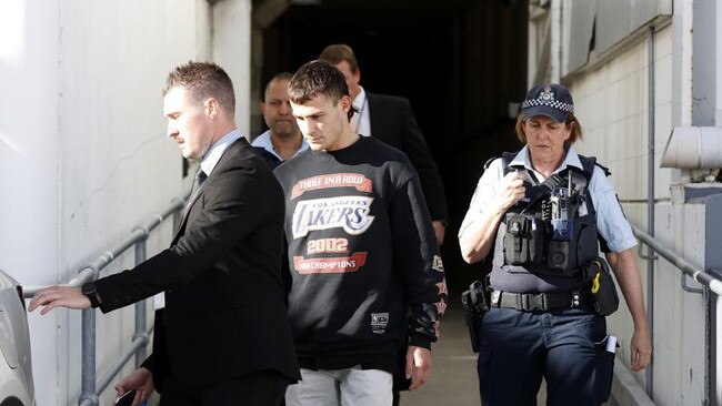 Garside leaving Sydney International Airport with NSW Police officers. Picture: Jonathan Ng