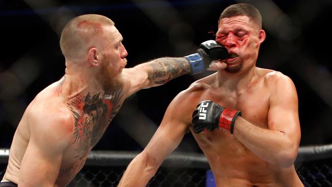 Conor McGregor (L) hits Nate Diaz with a left at UFC 202.