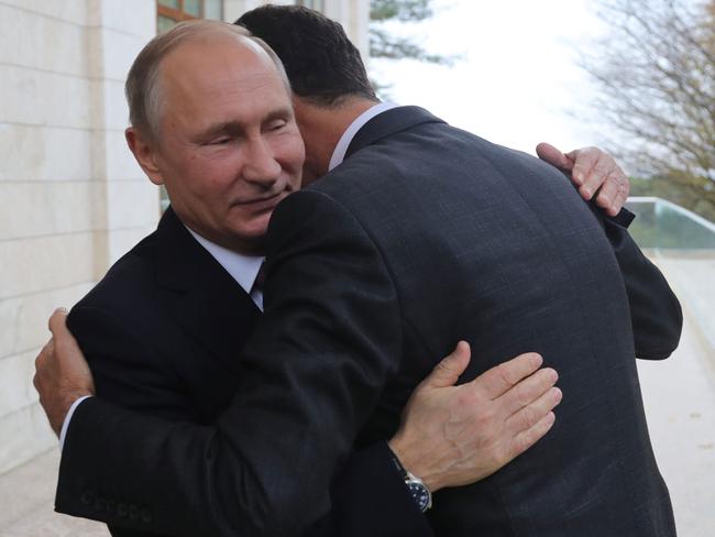 TOPSHOT - Russia's President Vladimir Putin (L) embraces his Syrian counterpart Bashar al-Assad during a meeting in Sochi on November 20, 2017. / AFP PHOTO / SPUTNIK / Mikhail KLIMENTYEV