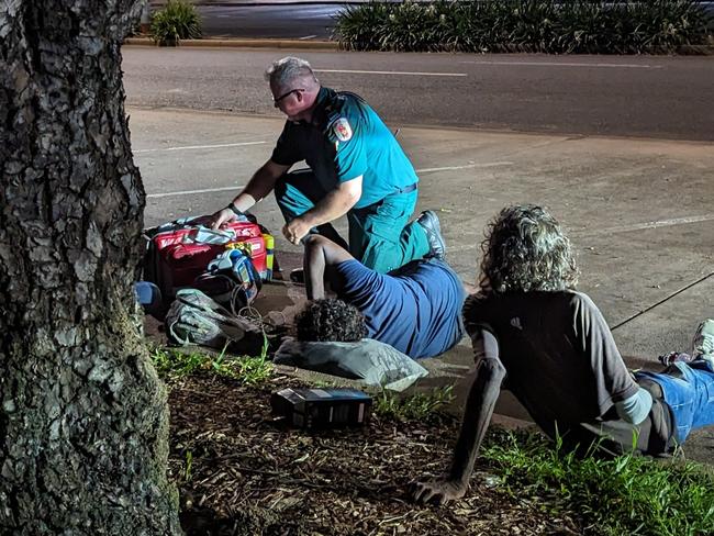 St John Ambulance NT's director of ambulance services Andrew Thomas treats Vera at Stuart Park as Sammy watches on. Picture: Alex Treacy