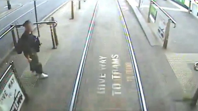 A woman steps out onto the tram tracks as an oncoming tram approaches. Picture: Yarra Trams