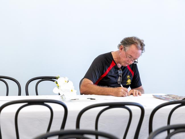 Hamish Findlay signs the condolences book at the Government House of Saturday morning. Picture: Floss Adams.