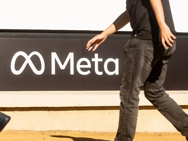 (FILES) A person walks past a newly unveiled logo for 