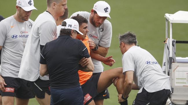 Jarrod Pickett is helped on to a buggy after hurting his knee.