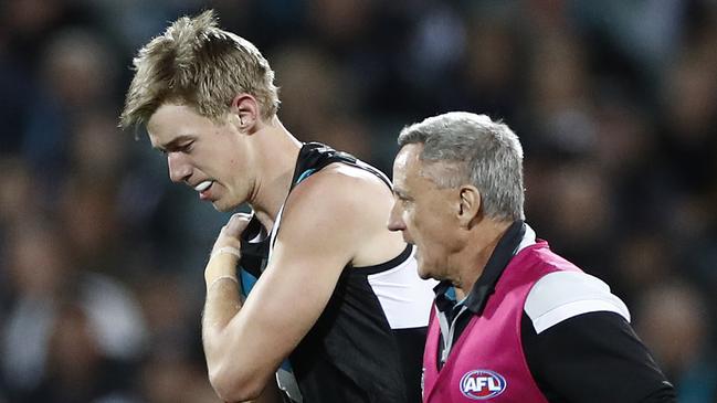 Todd Marshall leaves the field clutching his injured shoulder. Picture: Ryan Pierse/Getty Images