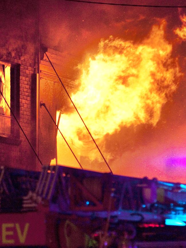 Flames leap from the apartments above the street. Picture: Tom Hancock