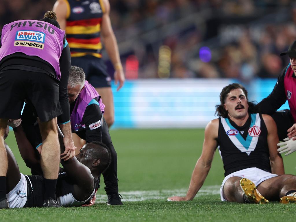 Aliir Aliir with Lachie Jones are both helped by club doctors last season for Port Adelaide, in an incident which caused the Power to cop heat over its treatment of concussion. Picture: Sarah Reed/AFL Photos via Getty Images.