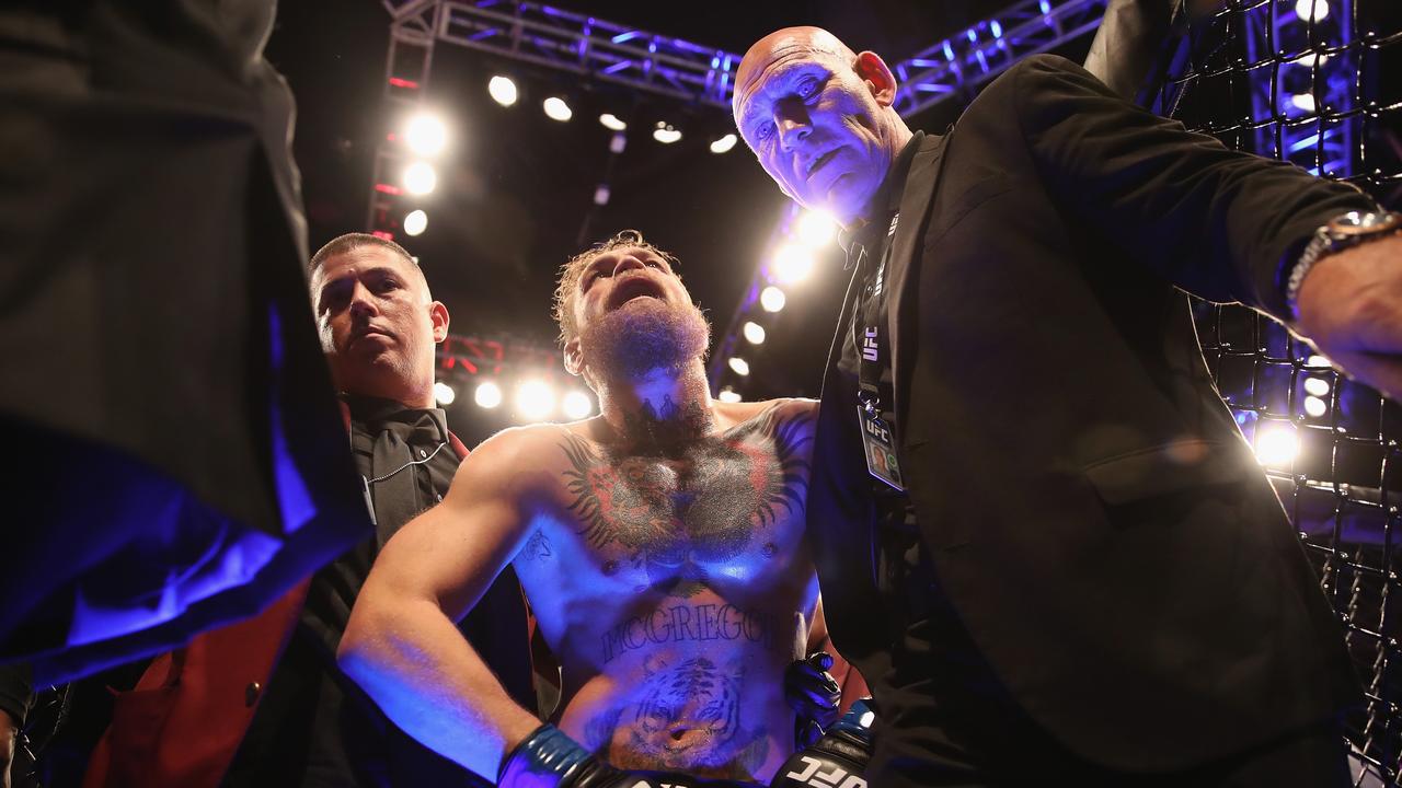 Conor McGregor of Ireland is escorted out of the Octagon.