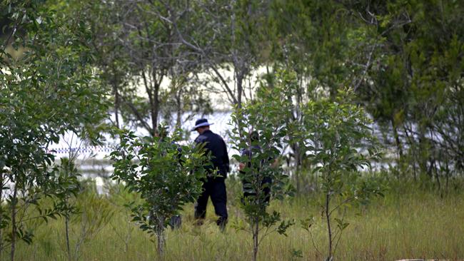 Police scouring the banks of a dam in Kingston. Picture: Jack Tran