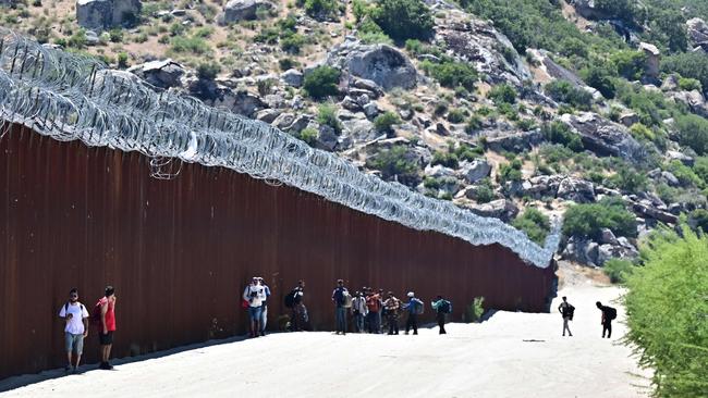 Migrants walk into the US beside the US-Mexico border wall at Jacumba Hot Springs, California, on June 5, 2024. Picture: AFP