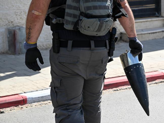 Members of the security forces carry a piece of a rocket after it was fired from Gaza and exploded on a house in Sderot, Israel. Picture: Getty Images