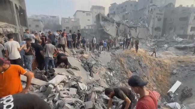 Palestinians looking for survivors in a crater following a strike on the Jabalia refugee camp in the northern Gaza Strip.