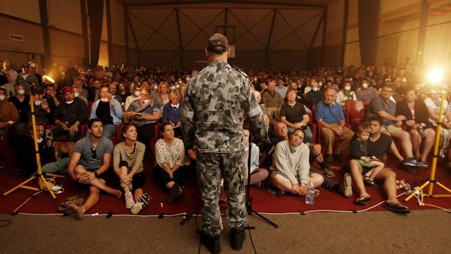 Commander Scott Houlihan of HMAS Choules talks to the hundreds gathered at a Mallacoota Town Hall meeting about evacuation on the ship. Picture: David Caird