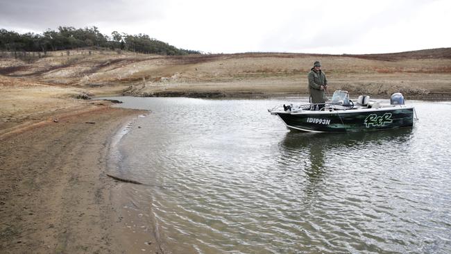 Fisherman Matthew Plain drops a line in the puddle that was the Burrendong Dam near Wellington. Picture: Dean Marzolla