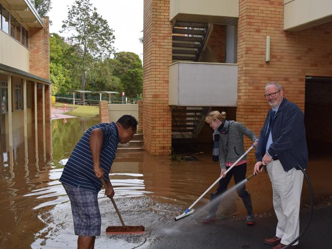 Trinity College principal Br John Hilet helps clean up the school ready for opening today.