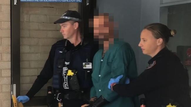 Police escort alleged Darwin gunman Ben Hoffmann from Royal Darwin Hospital on Thursday before charging him with four counts of murder. PICTURE: NTPFES