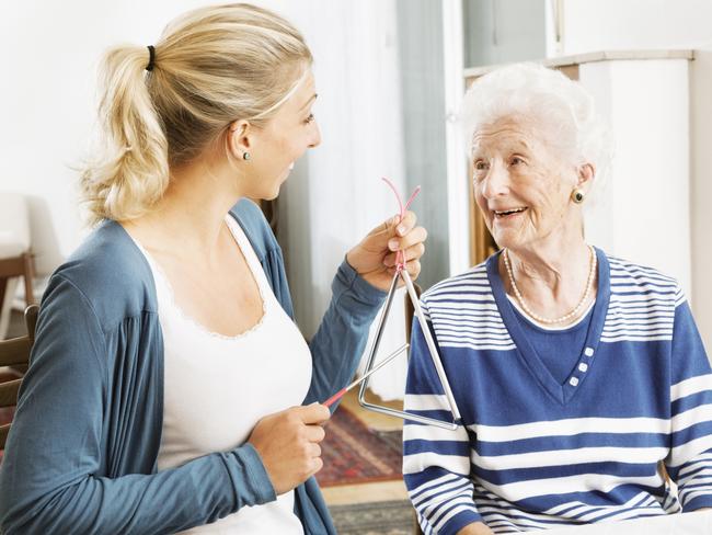 MUSIC THERAPY: Using music can help both those living with dementia, their carers and family members.young therapist playing a triangle to senior woman, music therapy , useful especially for people with Alzheimer disease