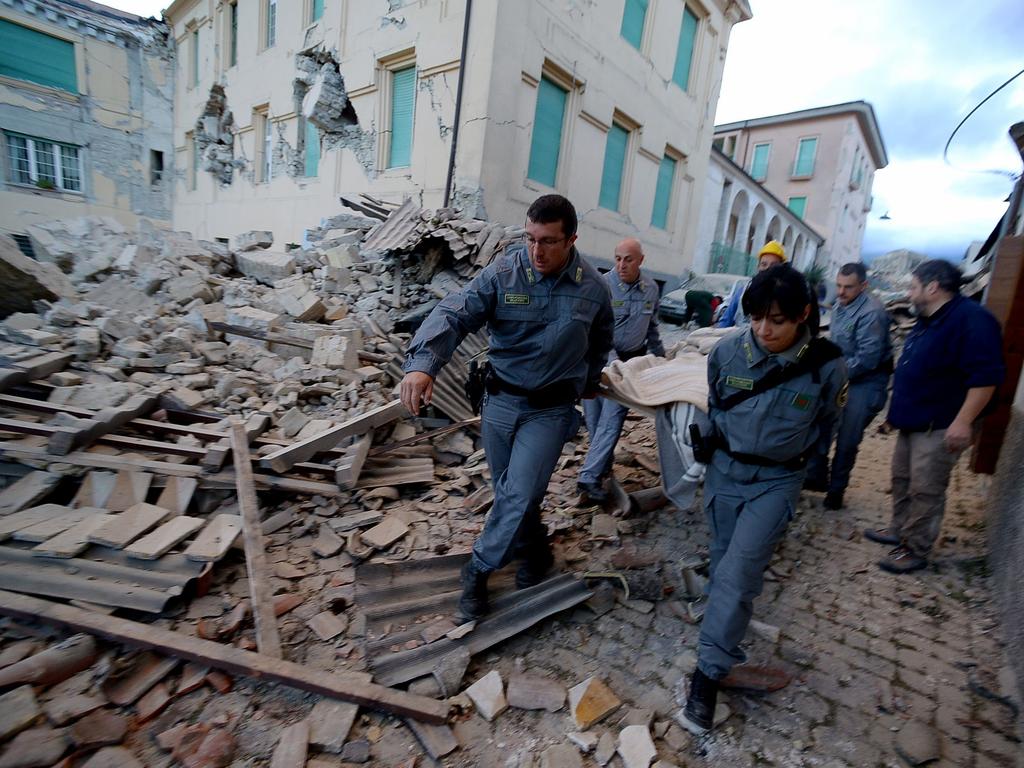 Rescuers carry a man from the rubble after a strong earthquake hit Amatrice on August 24, 2016. Picture: AFP