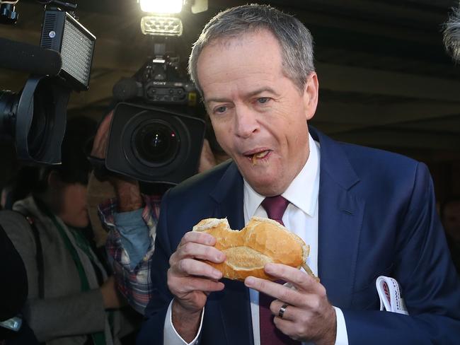 Burglary with the lot: Opposition Leader Bill Shorten (pictured eating a sausage sandwich at Election Day), has been urged to start opposing union deals. Picture Kym Smith