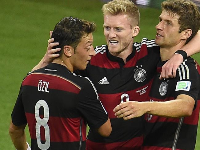 TOPSHOTS Germany's forward Andre Schuerrle (C) celebrates after scoring his team's sixth goal with Germany's midfielder Mesut Ozil and Germany's forward Thomas Mueller during the semi-final football match between Brazil and Germany at The Mineirao Stadium in Belo Horizonte on July 8, 2014, during the 2014 FIFA World Cup. AFP PHOTO / ODD ANDERSEN