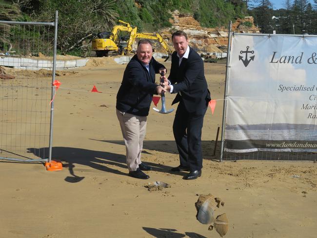 Terrigal state Liberal MP Adam Crouch and council’s Jamie Barclay get good hang time as they toss the first sod at the start of construction for the boardwalk. Picture: Richard Noone