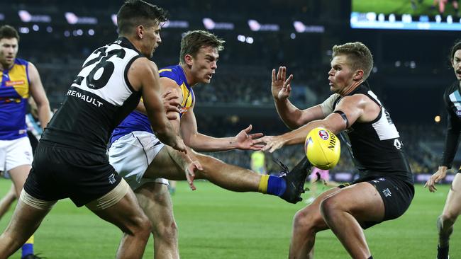 Luke Partington gets his kick past Dan Houston in a 2017 clash between West Coast and Port Adelaide. Picture: Sarah Reed