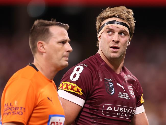 TOWNSVILLE, AUSTRALIA - JUNE 09:  Christian Welch of the Maroons is attended to by a team trainer after a tackle during game one of the 2021 State of Origin series between the New South Wales Blues and the Queensland Maroons at Queensland Country Bank Stadium on June 09, 2021 in Townsville, Australia. (Photo by Mark Kolbe/Getty Images)