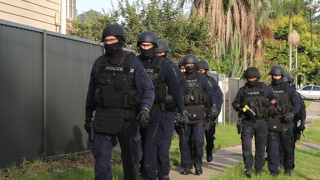 Members of Strike Force Woden approaching the man’s Villawood home. The 27-year-old will face 13 counts of fraud on Friday – NSW POLICE