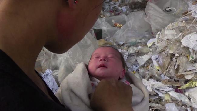 A mother tends to her newborn surrounded by the West’s plastic recycling rubbish in the <i>Plastic China </i>documentary.