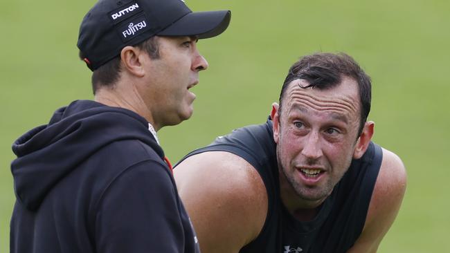 MELBOURNE , AUSTRALIA. February 17 , 2024.  AFL. Essendon training at the Hangar, Tullamarine. Todd Goldstein talks with Brad Scott, senior coach of the Bombers    during training today  . Pic: Michael Klein