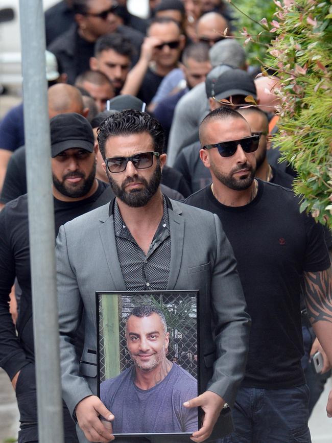 One mourners holds a framed photo of Mahmoud Hawi.