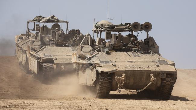 Israeli armoured personnel carriers move near the border with the Gaza Strip on Monday. Picture: Getty Images