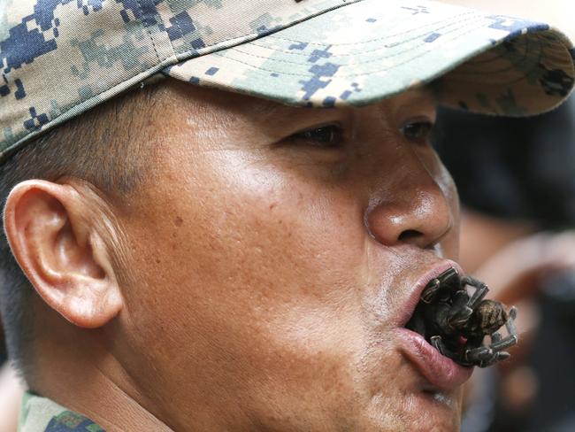A Thai Marine instructor eats a tarantula as he gives instruction to US Marines and South Korean Marines during jungle survival training. Picture: Rungroj Yongrit / EPA