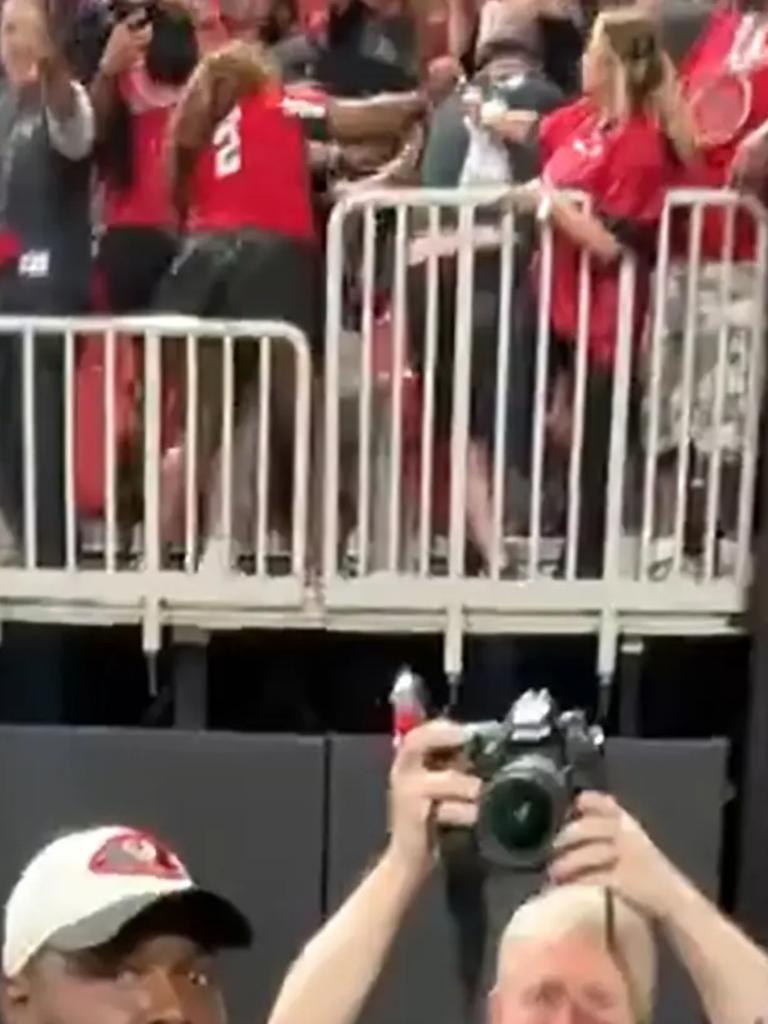 Two fans throw hands in the stands.