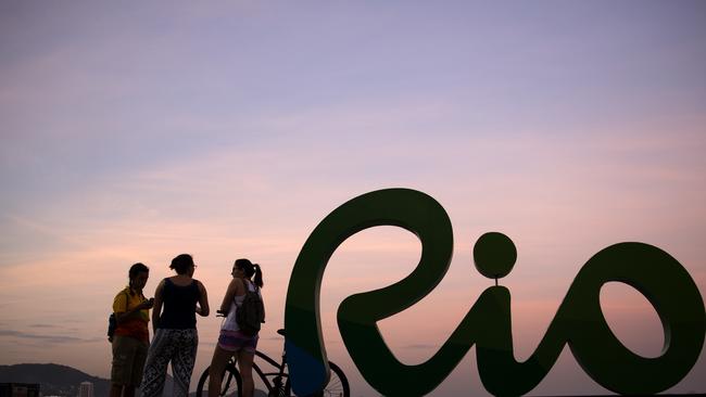 Pedestrians stand along the waterfront at Copacabana beach, site of the cycling road race, beach volleyball, marathon swimming and triathlon competitions at the 2016 Summer Olympics, in Rio de Janeiro, Brazil, Saturday, Aug. 6, 2016. (AP Photo/David Goldman)