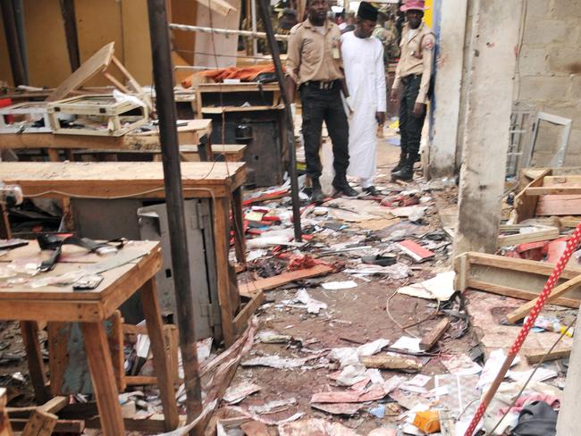 Rescue workers inspect the scene of an explosion at a mobile phone market in Kano, Nigeria. Picture: AP