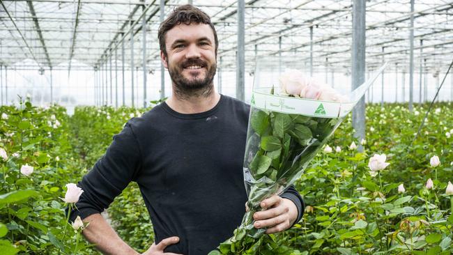 Clear message: Michael Allen from Bloomin’ Koomen in Pakenham with glasshouse-grown roses that are sold with an Australian Grown logo on the packaging. Picture: Dannika Bonser