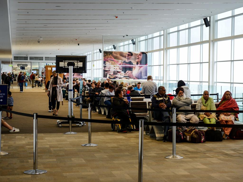 Travellers wait in the international departure lounge for their aircraft to arrive. Picture: AAP / Brenton Edwards