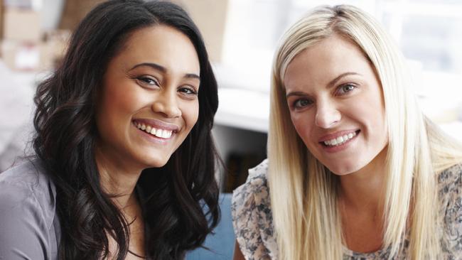 Young coworkers smiling while sitting in their office. Picture: iStock