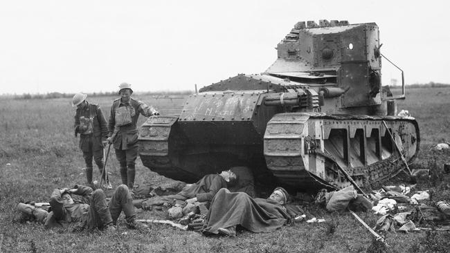 A British Tank used in the battle of Hamel sheltes wounded Australians of the 15th Brigade, and wounded German prisoners near Harbonnieres, in 1918.