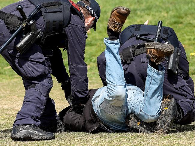 Police tackle a protester. Picture: Ian Currie