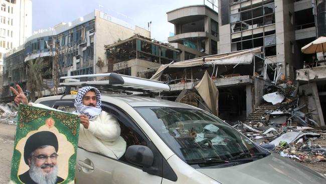 A man waves the portrait of slain Hezbollah leader Hassan Nasrallah as he arrives in the southern Lebanese city of Nabatieh this week as displaced people make their way back to their homes in the south of Lebanon after the ceasefire between Israel and Hezbollah took effect. Picture: Mahmoud Zayyat / AFP